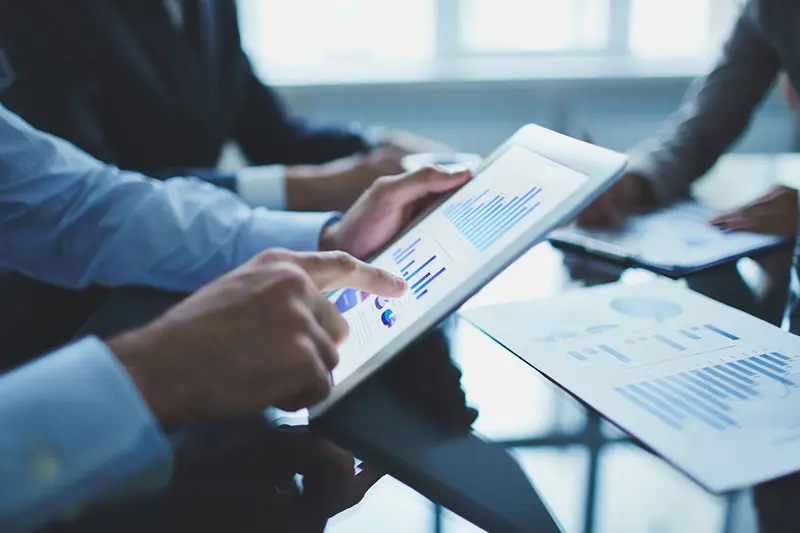 Consultor apontando um relatório no tablet durante reunião